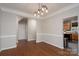 Neutral dining room with hardwood floors, elegant lighting, and access to the kitchen at 303 Basswood Ct, Clover, SC 29710