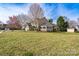 A large green lawn shows a house with a covered deck and a tree-lined street at 303 Basswood Ct, Clover, SC 29710