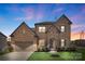 Charming brick home with a two-car garage and manicured lawn at dusk at 3045 Bronwood Pl, Lancaster, SC 29720