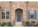 Charming front entrance with stone detail, blue door, and colorful flower accents at 3045 Bronwood Pl, Lancaster, SC 29720