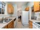 Galley kitchen with white appliances and a view into the dining room at 3604 Oakwood Rd, Charlotte, NC 28269