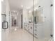 Open bathroom featuring marble tile, walk-in shower, dual sinks, and entrance to a walk-in closet at 3937 Plainview Rd, Charlotte, NC 28208