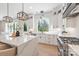 Well-lit kitchen boasts an island with barstool seating, stainless steel appliances, and backyard views at 3937 Plainview Rd, Charlotte, NC 28208