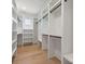 A large walk-in closet featuring hardwood floors, a window, and ample storage and shelving space at 3937 Plainview Rd, Charlotte, NC 28208
