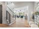 Bright and spacious foyer that flows into a cozy living room with a modern staircase and designer decor at 3949 Plainview Rd, Charlotte, NC 28208