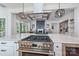 Large kitchen island with stainless steel stove and view into the living room at 3949 Plainview Rd, Charlotte, NC 28208