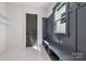 Mudroom with convenient storage, a built-in bench, and light colored tile flooring at 3949 Plainview Rd, Charlotte, NC 28208