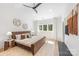 Bright bedroom featuring a ceiling fan, decorative wall art, large windows, and an inviting, cozy bed at 3953 Plainview Rd, Charlotte, NC 28208