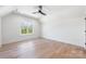 Bright bonus room with a ceiling fan, hardwood floors, large windows, and a vaulted ceiling at 3953 Plainview Rd, Charlotte, NC 28208