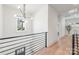 Hallway featuring black steel railing, wood floor and a modern chandelier at 3953 Plainview Rd, Charlotte, NC 28208