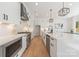 Modern kitchen featuring white cabinets, stainless steel appliances, and a stylish range hood at 3953 Plainview Rd, Charlotte, NC 28208