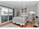 Bright bedroom featuring a four-poster bed, hardwood floors, and balcony access for a refreshing space at 452 S Main St # F, Davidson, NC 28036