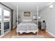 Bright bedroom with a four poster bed, hardwood floors, balcony access, and mirrored accent decor at 452 S Main St # F, Davidson, NC 28036