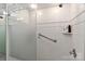 Bathroom shower featuring white tiling, a glass door, grab bar, and built in shelf at 452 S Main St # F, Davidson, NC 28036