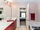 Bathroom showcasing double sinks, red cabinets, and access to the main bedroom at 4708 Chantress Ln, Monroe, NC 28110