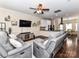 Cozy living room featuring hardwood floors, a ceiling fan, and comfortable gray reclining sofas at 4708 Chantress Ln, Monroe, NC 28110