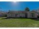 This backyard boasts mature trees, well-maintained lawn, and a quaint patio accessible through sliding glass doors at 4715 Cricklewood Ln, Charlotte, NC 28212