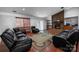 Spacious living room featuring a stone fireplace, hardwood floors, and comfortable leather seating at 4715 Cricklewood Ln, Charlotte, NC 28212
