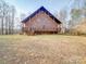 Spacious backyard showcasing a brick home with a generous deck at 5687 Putuptoe Pl, Norwood, NC 28128