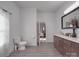 Bathroom featuring toilet, vanity with double sinks, and bedroom view at 5687 Putuptoe Pl, Norwood, NC 28128