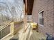 Freshly stained back deck with wooden floors and black metal railing, brick siding at 5687 Putuptoe Pl, Norwood, NC 28128