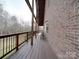 Side view of the deck with brown wooden floors and brick siding at 5687 Putuptoe Pl, Norwood, NC 28128