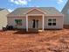 The back of the home has a small covered porch, sliding glass doors, and large windows at 5712 Skinny Ln, Charlotte, NC 28215