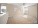 Large room with neutral walls, beige carpet, ceiling fan, multiple windows, and a white railing at 576 Putting Dr, Fort Mill, SC 29715