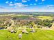 Expansive aerial view showcasing the property's setting amidst rolling green fields, lush trees, and tranquil rural neighborhood at 590 County Line Rd, Stony Point, NC 28678