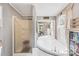 Bathroom featuring a walk-in shower, soaking tub, and neutral color scheme at 590 County Line Rd, Stony Point, NC 28678
