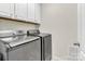 Laundry room with modern, gray, front-loading washer and dryer set at 7316 Strawberry Fields Ln, Charlotte, NC 28278