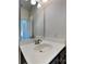 A bathroom with a round sink, vanity with faucet, mirror, and lights above at 8906 Paddle Oak Rd, Charlotte, NC 28227