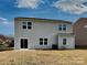 Rear exterior view of a two-story home with siding, several windows, and a patio at 8906 Paddle Oak Rd, Charlotte, NC 28227