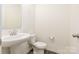 Half bath features a pedestal sink, toilet, and modern fixtures at 8915 Myra Way # 39, Charlotte, NC 28215