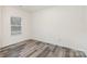 This bedroom features wood-look flooring and a window with blinds at 8915 Myra Way # 39, Charlotte, NC 28215
