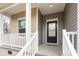 View of the cozy front porch with white railings, a black front door, and a small window at 8915 Myra Way # 39, Charlotte, NC 28215