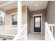 A closeup of the front porch with a black front door and a window on the beige-colored siding at 8915 Myra Way # 39, Charlotte, NC 28215