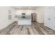 Modern kitchen with white cabinetry, stainless steel appliances, granite countertops and wood-look floors at 8915 Myra Way # 39, Charlotte, NC 28215