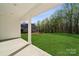 Backyard view showcases a spacious lawn, trees, and a glimpse of the home's exterior and landscaping at 902 Westminster Dr, Statesville, NC 28677
