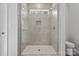 Modern tiled shower with glass door and transom window offers a bright and luxurious feel at 902 Westminster Dr, Statesville, NC 28677