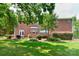 Expansive backyard featuring lush lawn, shade trees, patio and brick home exterior at 10625 Olde Irongate Ln, Mint Hill, NC 28227