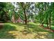Spacious, tree-lined backyard with lush green lawn and mature trees at 10625 Olde Irongate Ln, Mint Hill, NC 28227