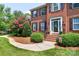 Elegant brick home with a beautifully landscaped yard, showcasing a classic front door and well-maintained surroundings at 10625 Olde Irongate Ln, Mint Hill, NC 28227