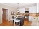 Modern kitchen features white cabinets, stainless steel appliances, and a center island with bar stool seating at 10625 Olde Irongate Ln, Mint Hill, NC 28227