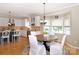 Bright kitchen area features stainless steel appliances, white cabinetry, hardwood floors, and an eat-in dining area at 10625 Olde Irongate Ln, Mint Hill, NC 28227