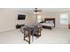 Open-concept room with a TV, sofa, bed, ceiling fan, desk and chair, creating a flexible living space at 10625 Olde Irongate Ln, Mint Hill, NC 28227