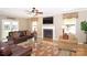 Comfortable living room featuring hardwood floors, a cozy fireplace, and large windows for natural light at 10625 Olde Irongate Ln, Mint Hill, NC 28227
