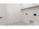 Practical laundry room featuring overhead cabinets, tiled floors, and convenient hookups, designed for efficient laundry tasks at 11032 Gary Player Dr # 961, Lancaster, SC 29720