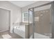 Well-lit bathroom featuring a glass shower, bathtub, and a sunlit window with blinds at 111 Bell Chase Ln, Statesville, NC 28677