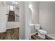 Charming half bathroom features a pedestal sink and matching commode with hardwood style flooring at 111 Bell Chase Ln, Statesville, NC 28677